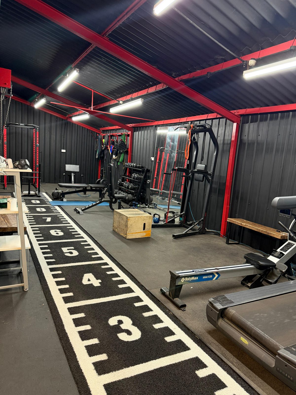 Inside the Warriors HQ studio — racks, dumbbells, cardio kit and the measuring-tape sled track
